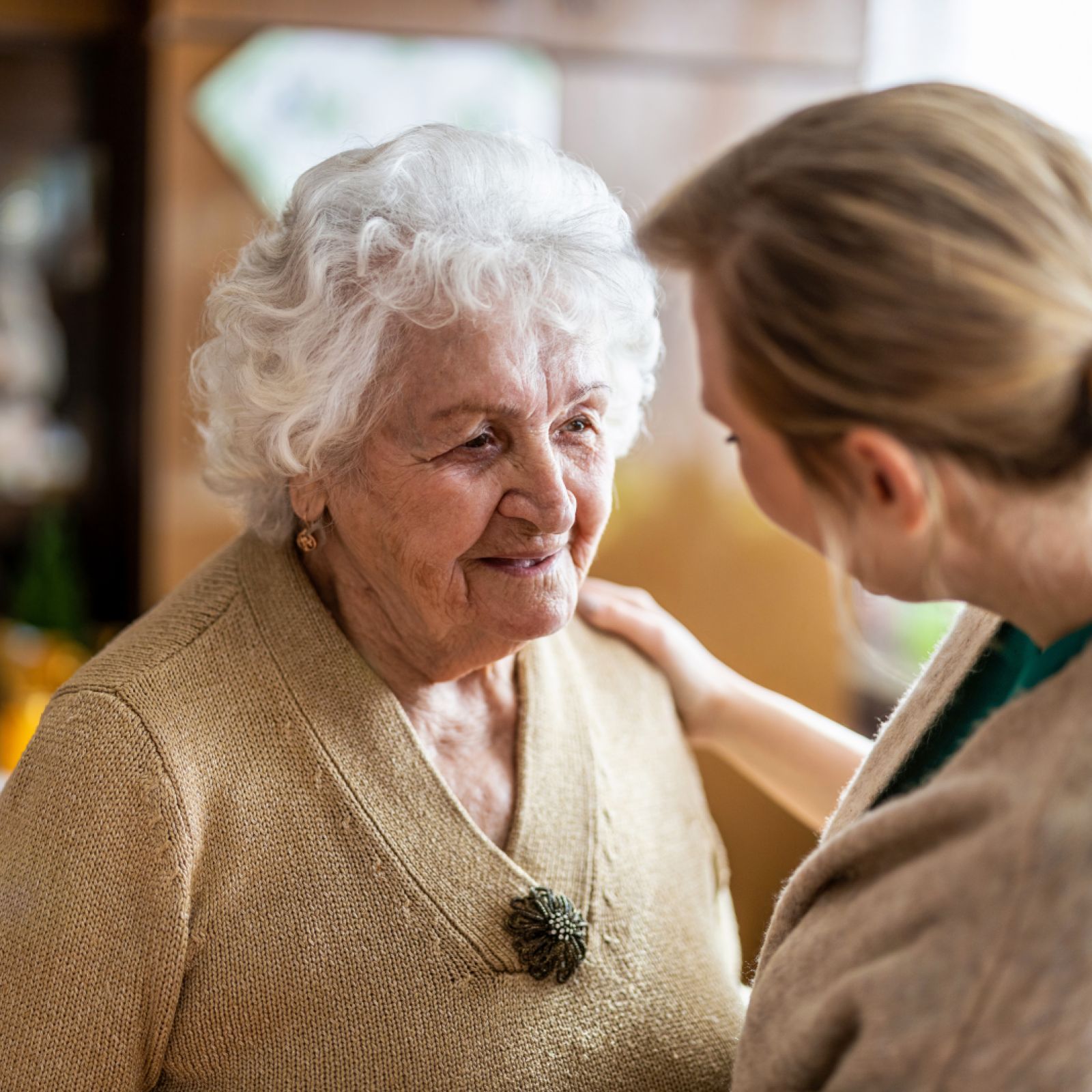 Senioren mit Betreuerin im Wohnzimmer im Gespräch
